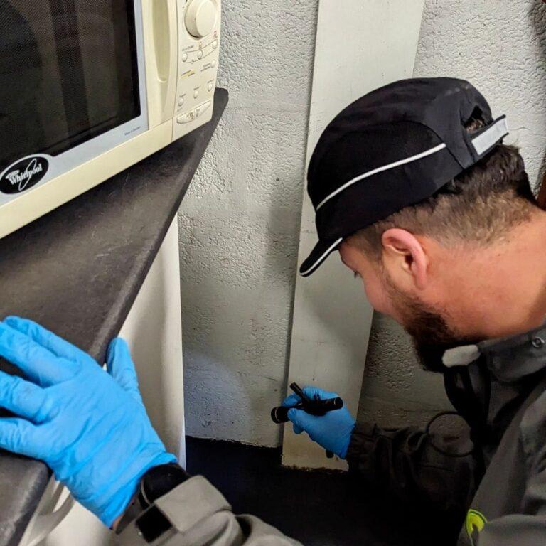 a man wearing gloves and holding a screwdriver