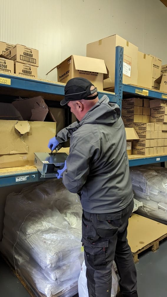 a man wearing gloves and holding a box